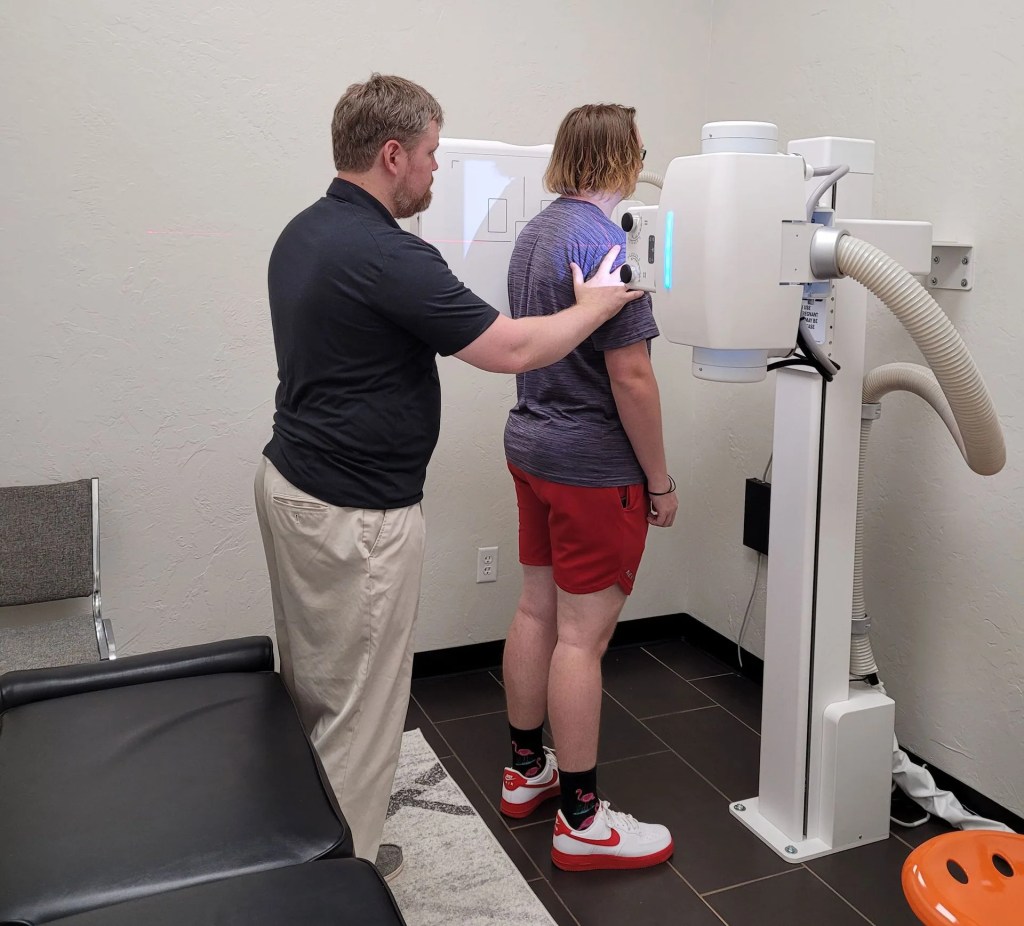 Dr. Dean positioning a patient for an X-ray at Innervate Chiropractic